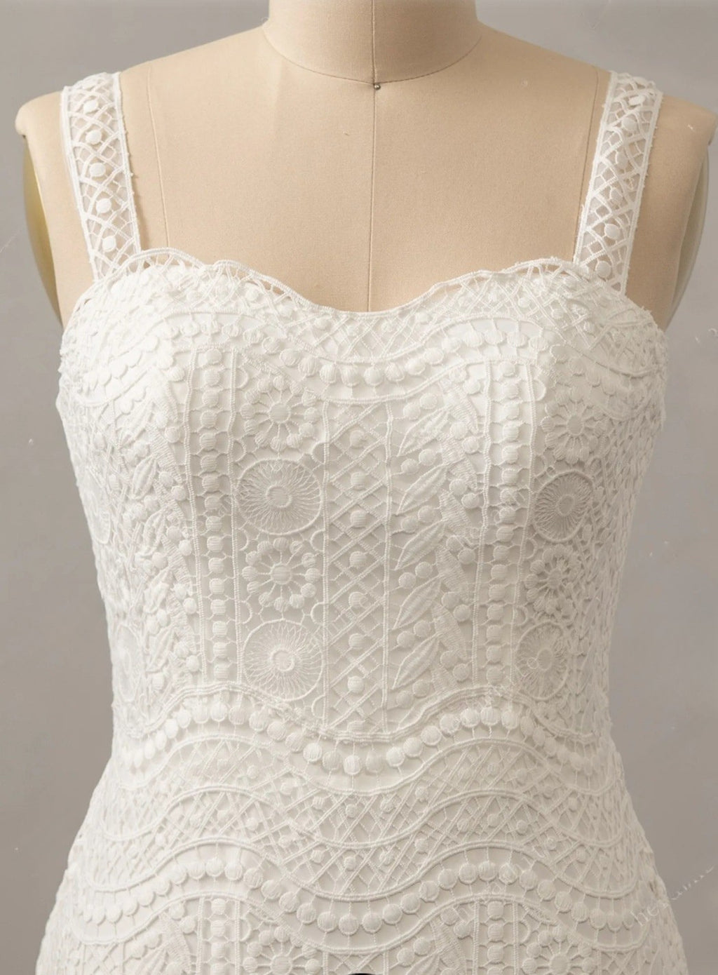 White lace dress on a mannequin against a gray background