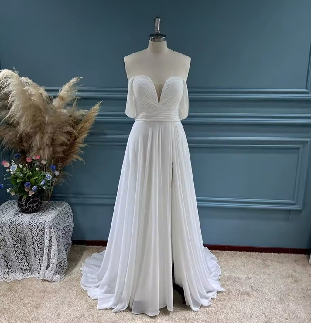 White evening gown on a mannequin against a blue wall with decorative elements.