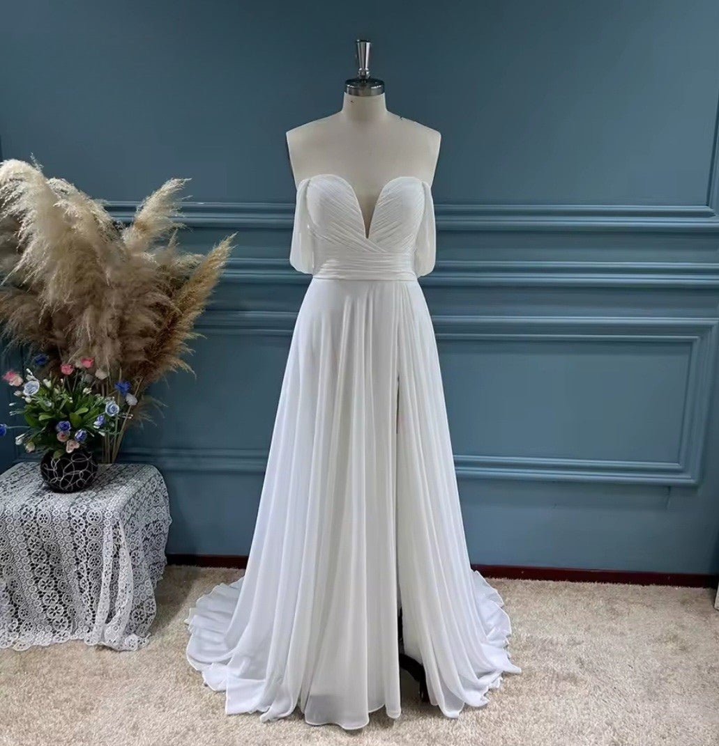 White evening gown on a mannequin against a blue wall with decorative elements.
