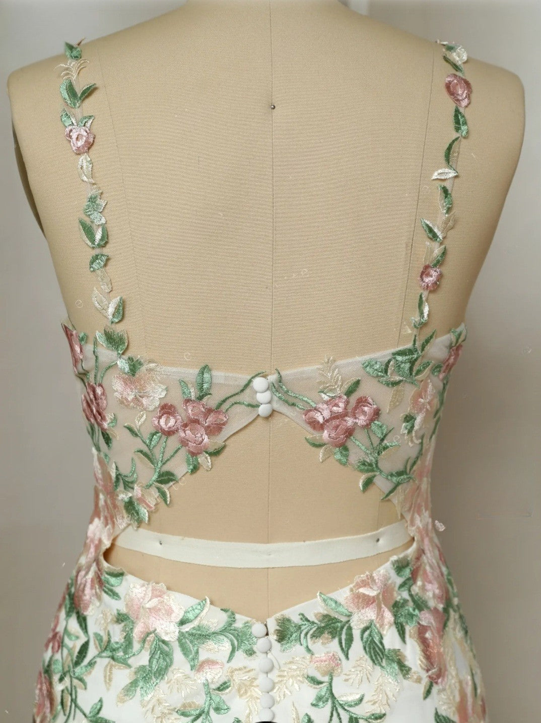 Floral embroidered dress on a mannequin against a plain background