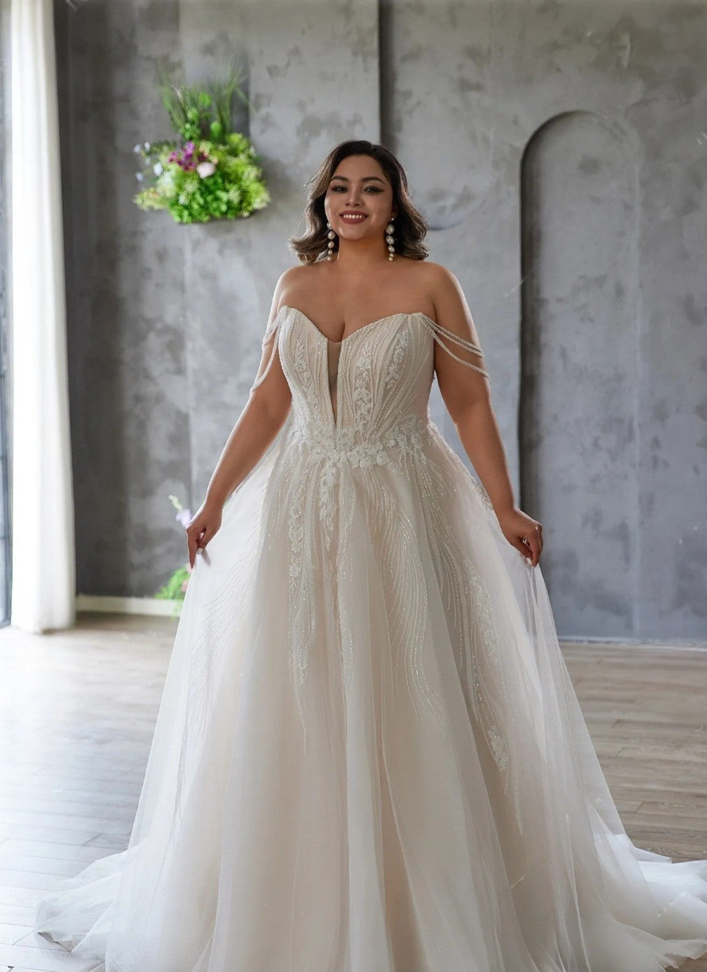 Woman wearing a white wedding dress in a room with a decorative wall.