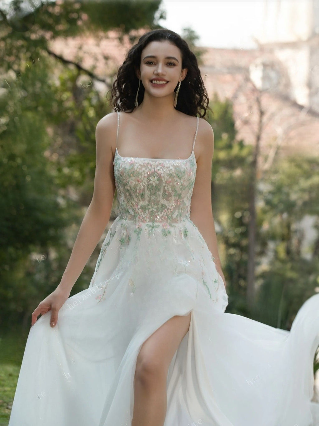 Woman in a floral dress standing outdoors with greenery in the background