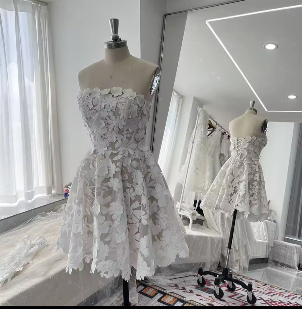 White lace dress on a mannequin in a room with large windows.