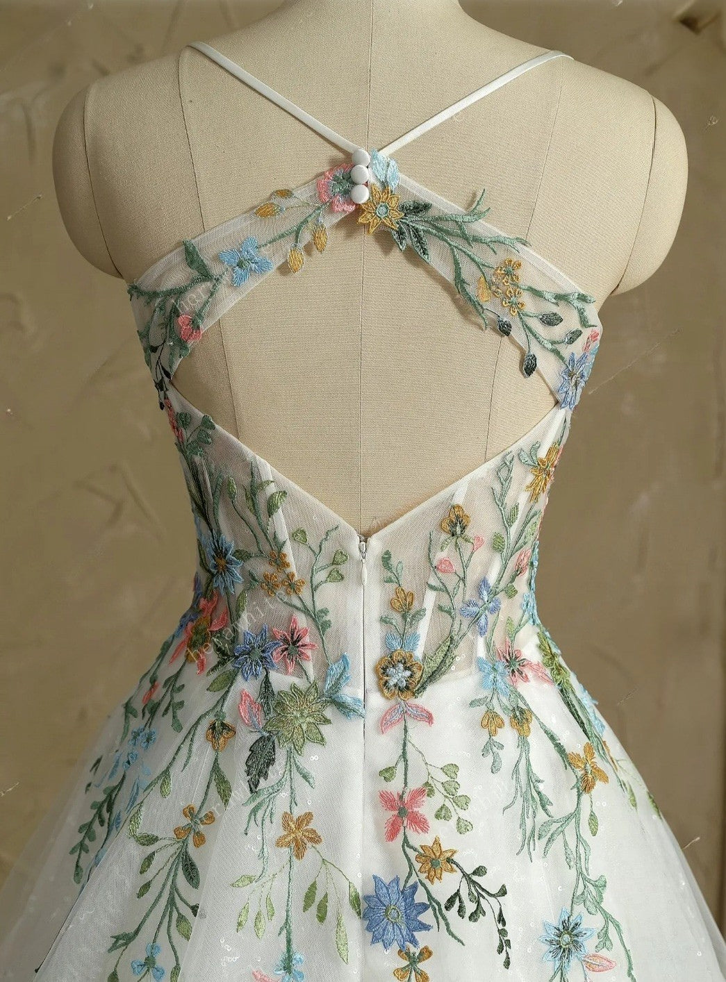 Floral embroidered dress on a mannequin with a neutral background