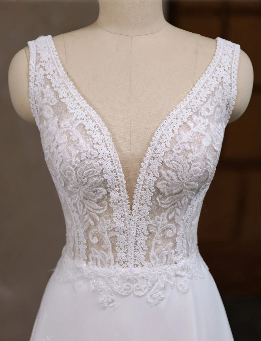 White lace wedding dress on a mannequin against a dark background
