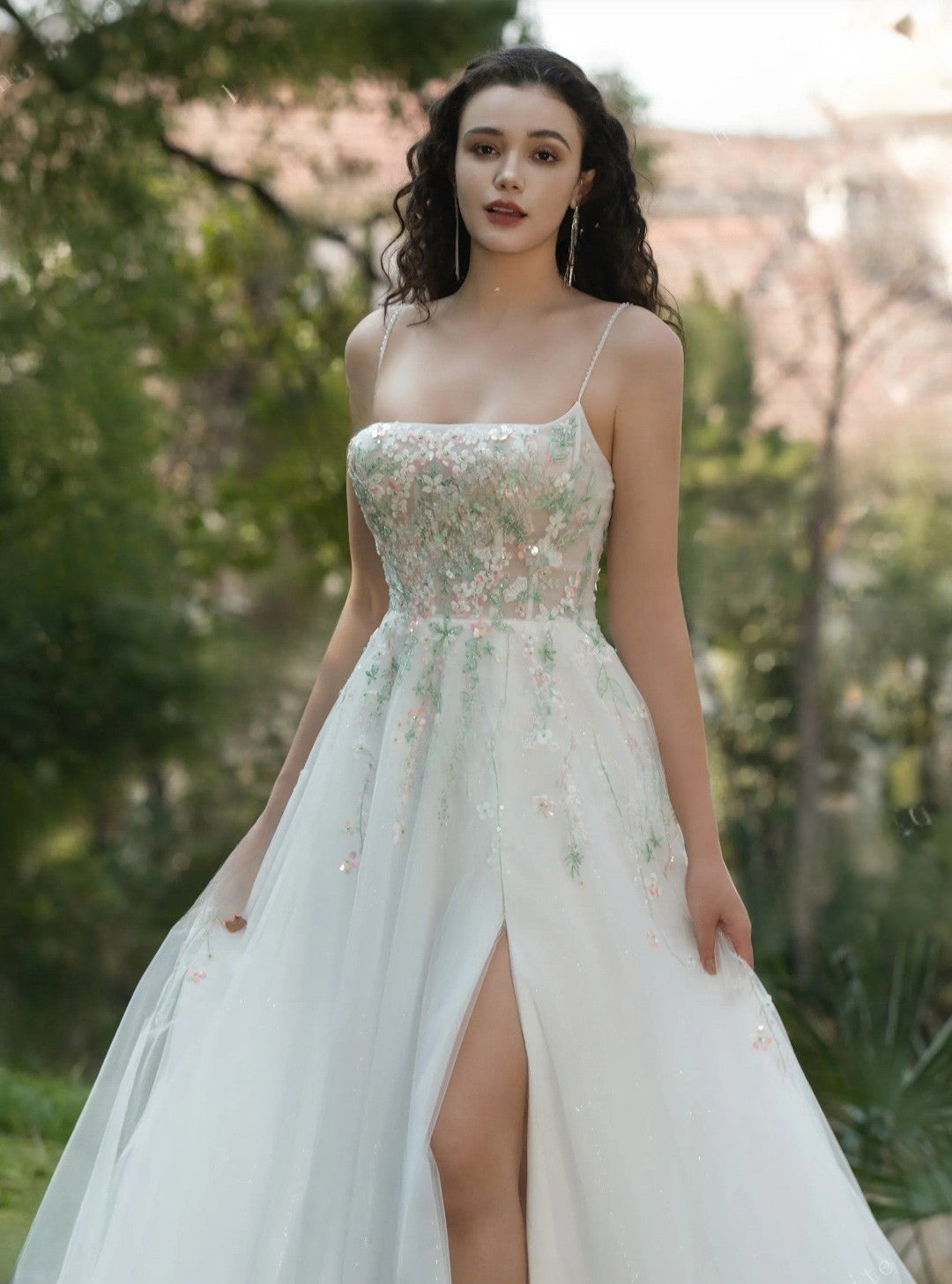 Woman wearing a floral dress with a slit in a garden setting